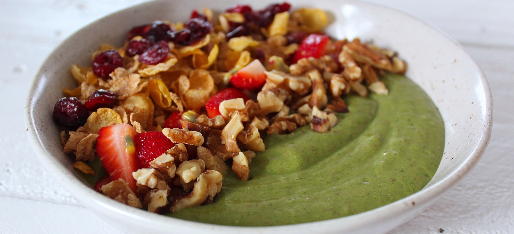 green-smoothie-bowl-decorated-with-fruit-and-nuts